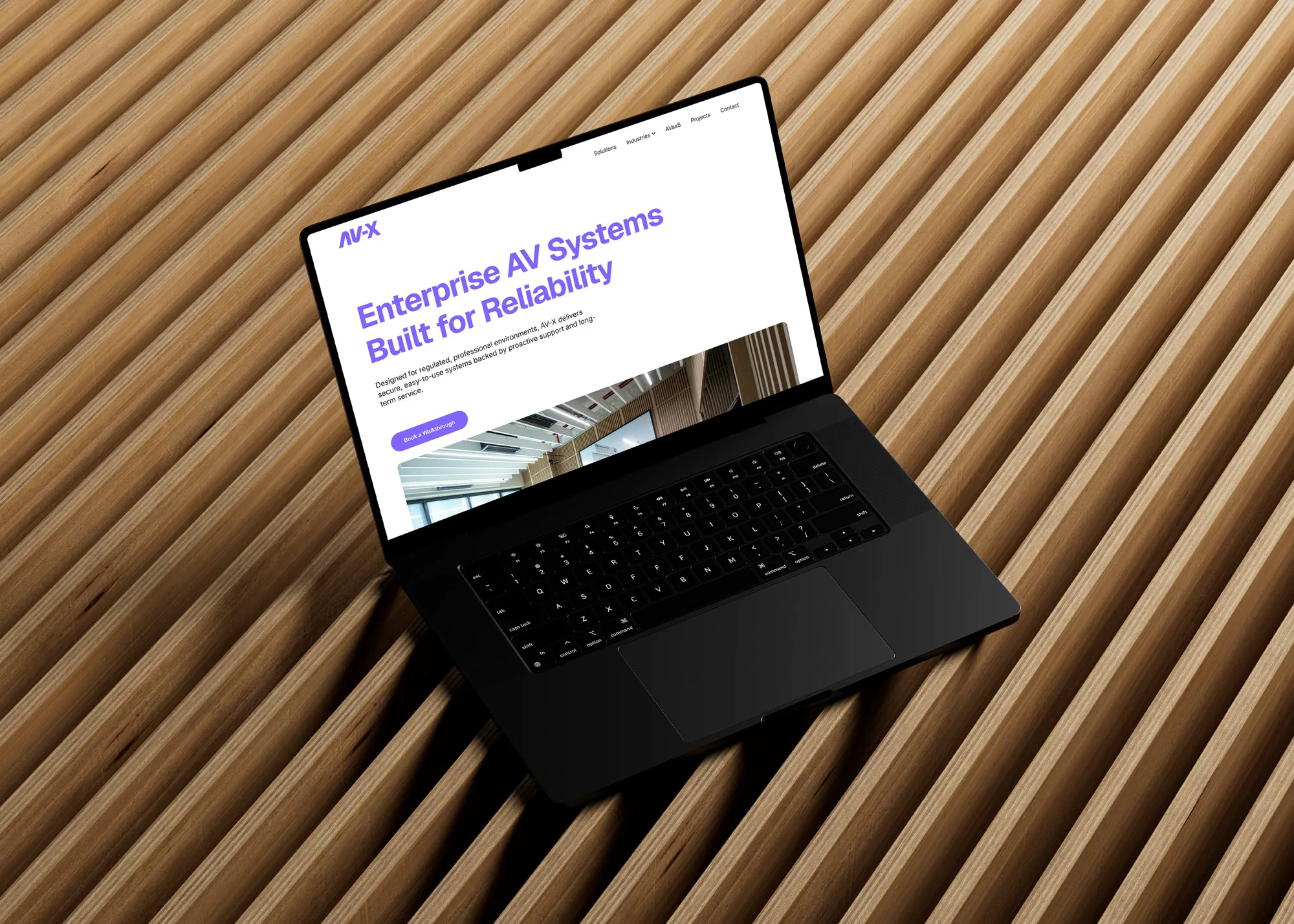 laptop on wood slats, showing the av-x website home page