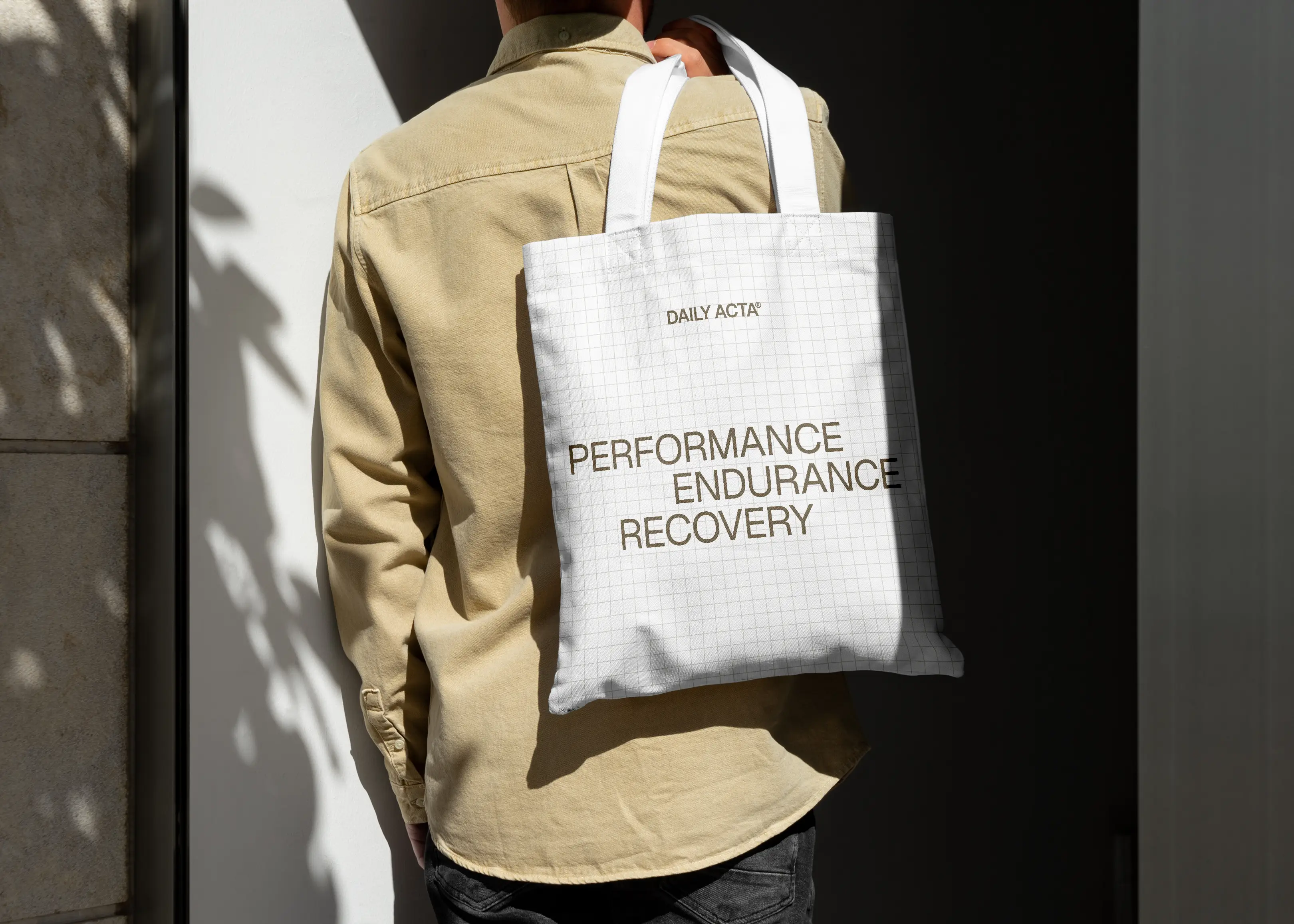  person holding white tote back over their shoulder, person is facing away