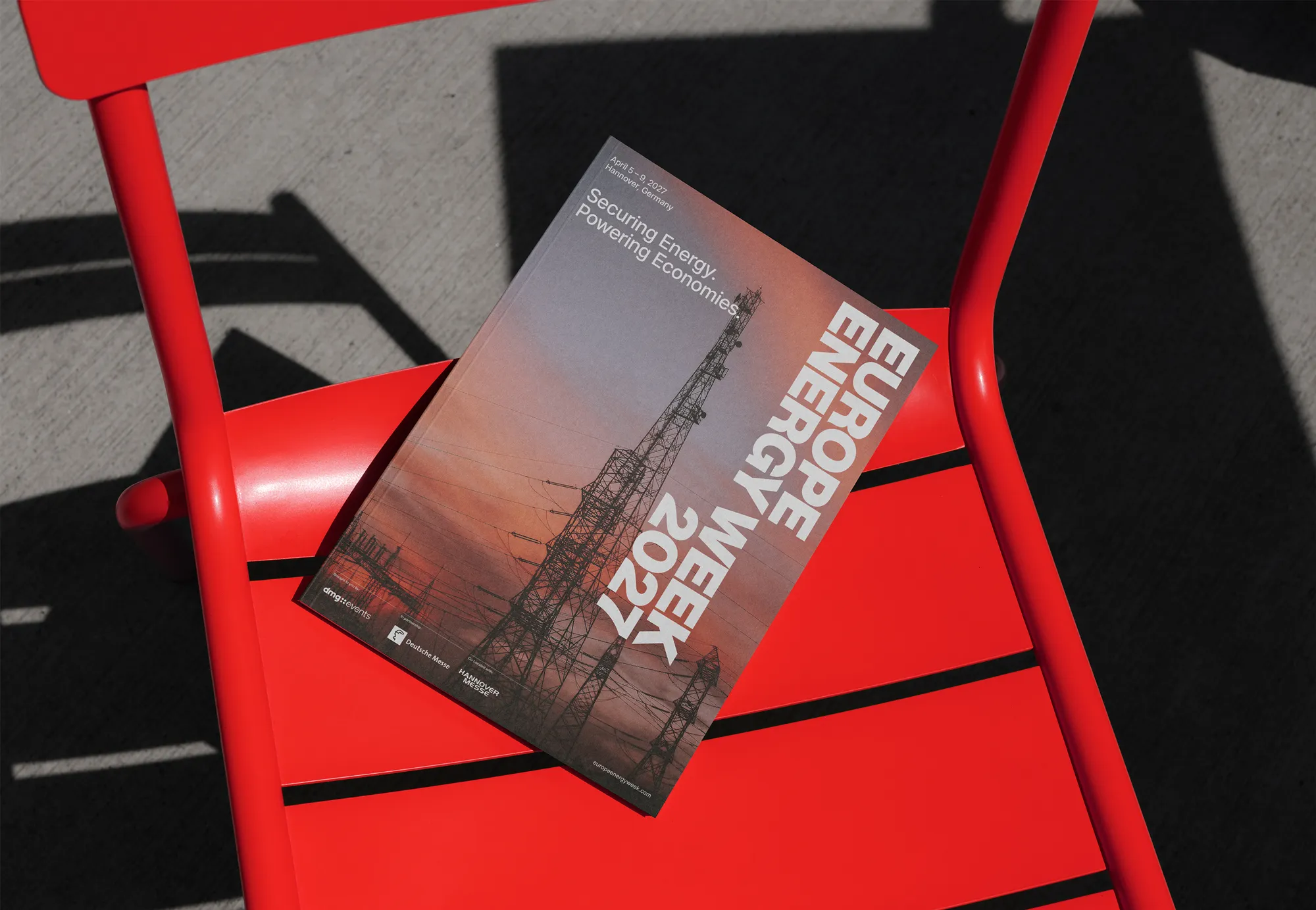 europe energy week 2027 brochure cover, placed on a red metal chair outside