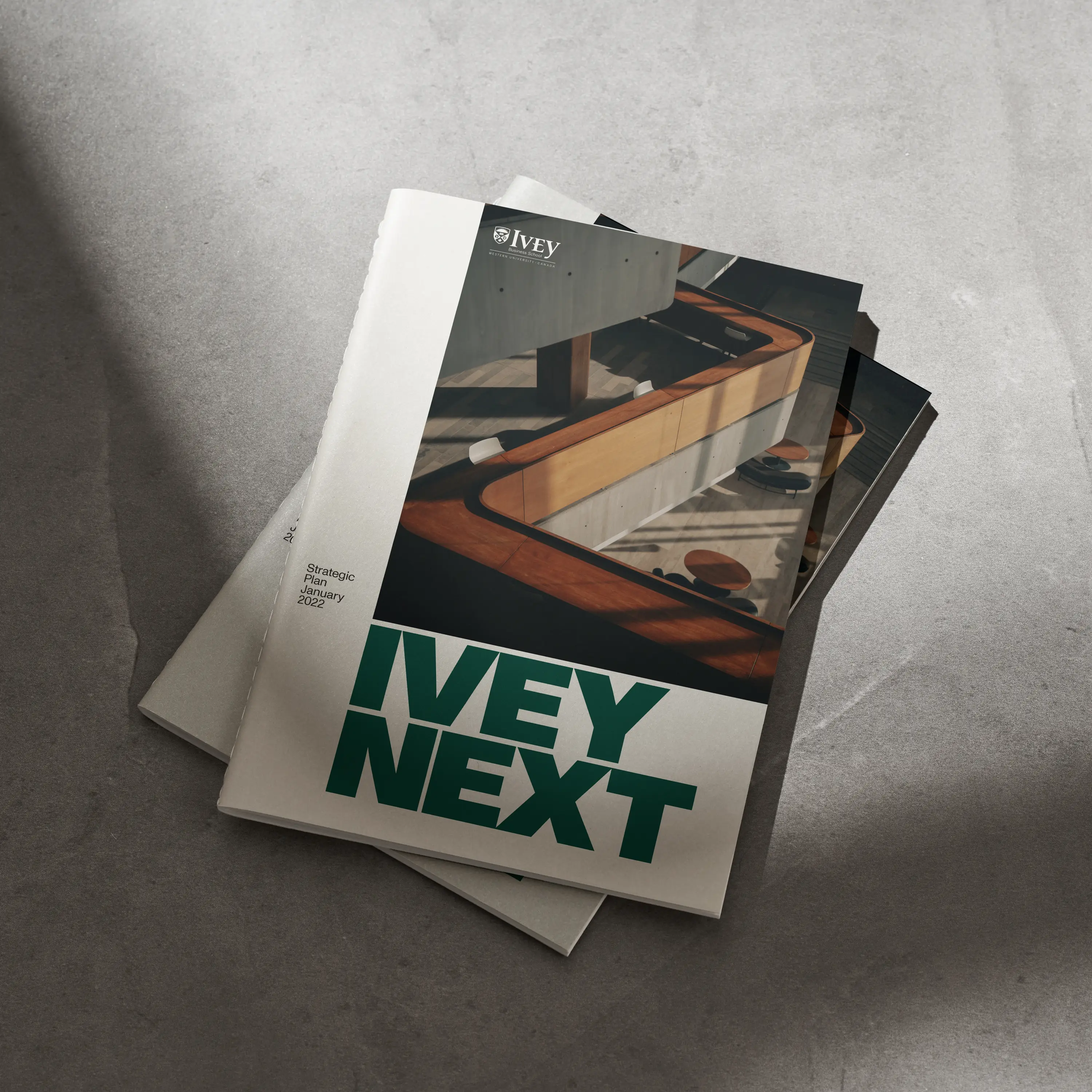  two editorial brochures stacked, on the floor 